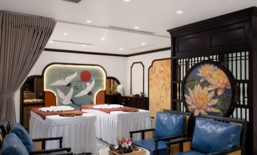 Elegant interior of a luxurious cruise cabin at ViettrendTour, featuring traditional Asian design elements and comfortable seating.