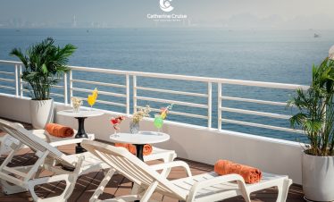 Relaxing seaside cruise deck with drinks and sun loungers - perfect vacation spot.