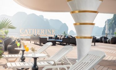 Elegant yacht deck with lounge chairs and scenic mountain views for luxury cruising.