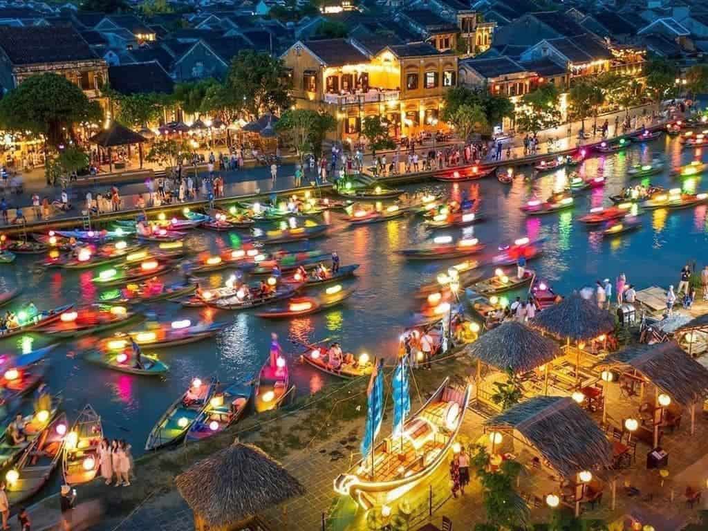 Vibrant night scene of colorful boats on the Thu Bon River in Hoi An, showcasing a lively and romant.