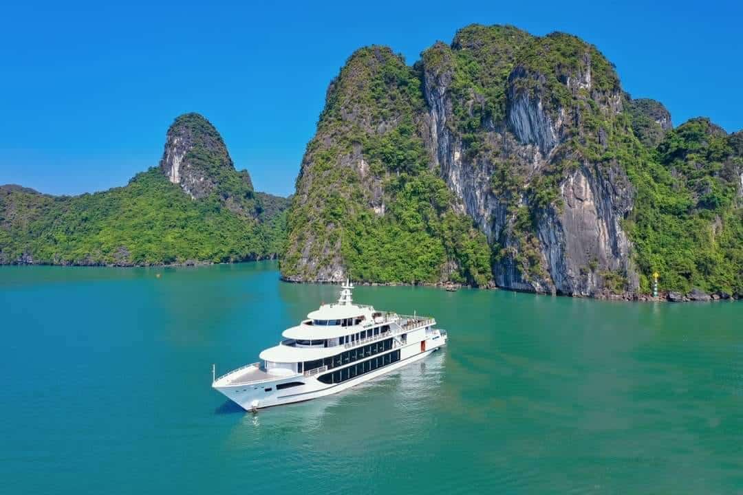 Beautiful scene of a luxury cruise sailing among limestone karsts in Halong Bay, Vietnam.