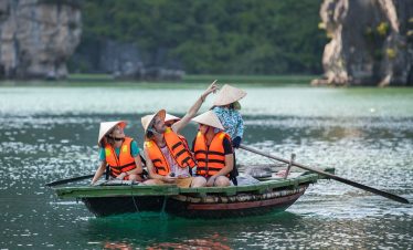 ViettrendTour group enjoying boat tour in Halong Bay, Vietnam, exploring scenic limestone islands.