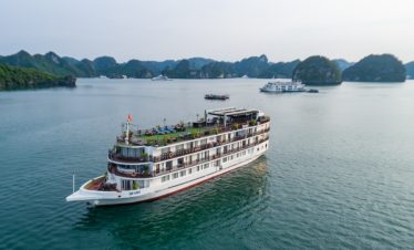 Luxury cruise ship sailing in Halong Bay, Vietnam with scenic limestone islands.