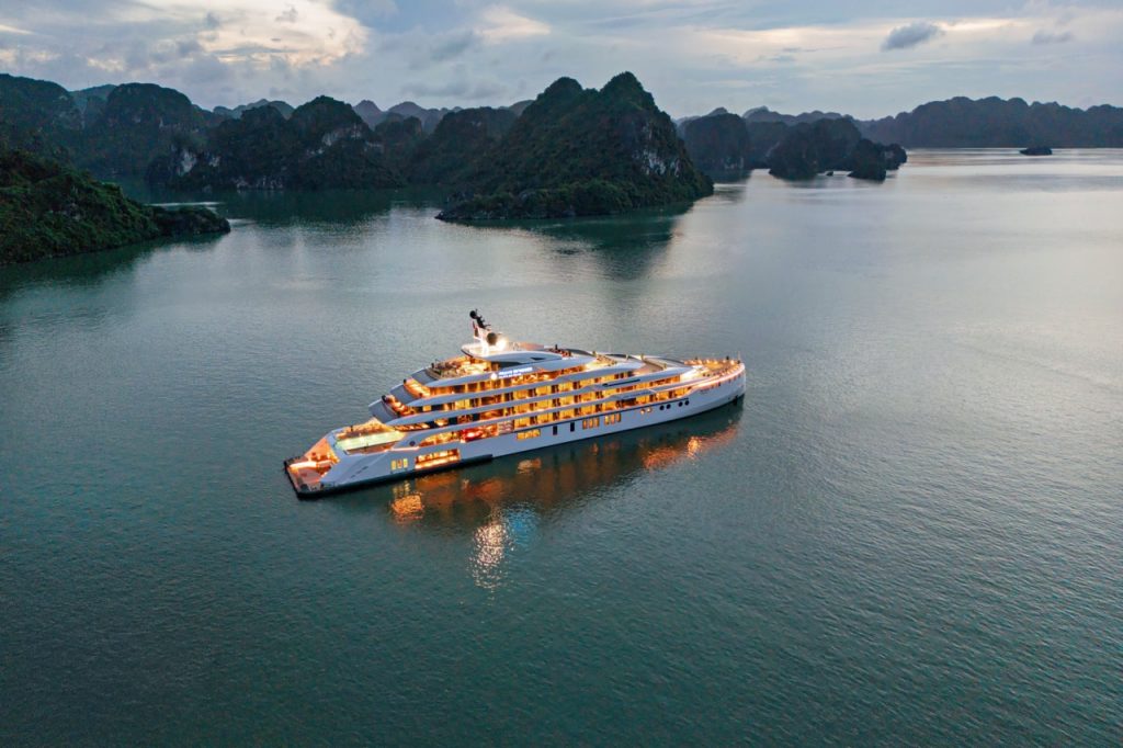 Luxurious yacht cruising Ha Long Bay in Vietnam at sunset.