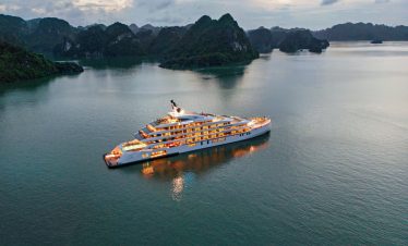 Luxurious yacht cruising Ha Long Bay in Vietnam at sunset.