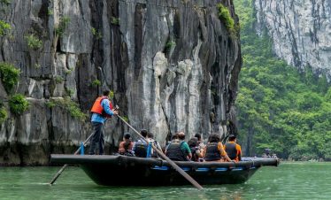 Amphibious boat tour exploring Ha Long Bay with limestone karsts and lush greenery in Vietnam.