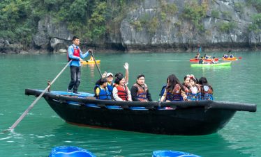 Enjoying group boat tour and kayaking adventure on stunning turquoise water in Vietnam.