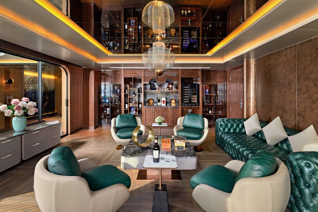 Luxurious modern lounge with stylish green and white seating, wooden accents, and elegant lighting.