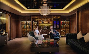 Elegant lounge with luxurious wood-paneled walls and modern lighting, perfect for upscale relaxation.