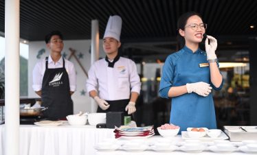 Culinary chef team preparing dishes at ViettrendTour cooking class, Vietnamese food experience.