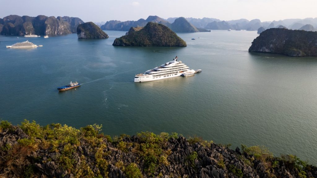 Luxury cruise ship in Halong Bay, Vietnam with emerald waters and limestone karsts.