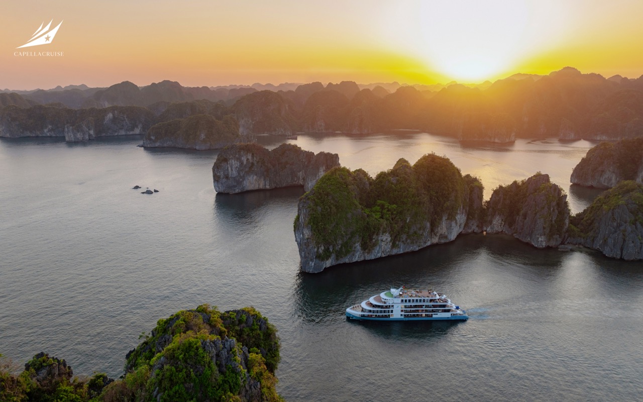 At sunrise, Capella Cruise glides through a natural ring of limestone islands in Lan Ha Bay, offering guests panoramic views and a peaceful start to their Vietnam cruise day.