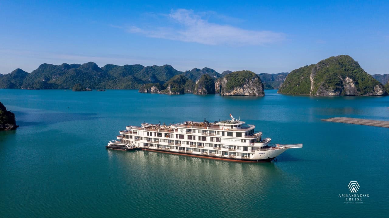 Ambassador Cruise Halong Bay ship sailing through turquoise waters of Halong Bay, scenic limestone islands, peacef.