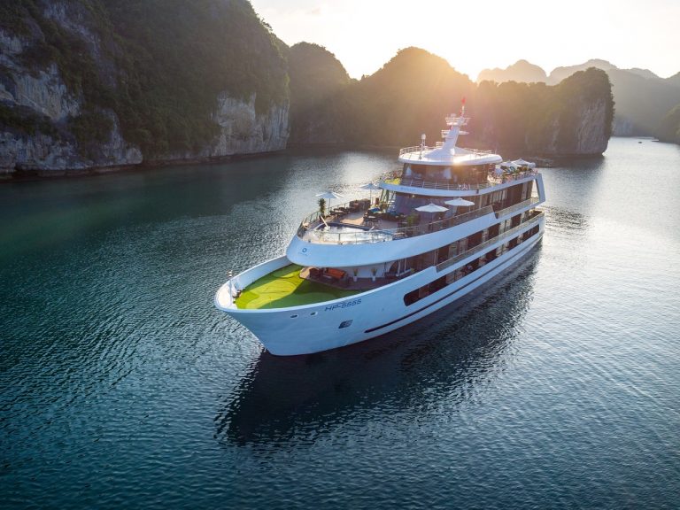 Full view of Stellar Of The Seas sailing between limestone cliffs in Lan Ha Bay, Vietnam. Join ViettrendTour for a stylish Halong Bay overnight cruise.