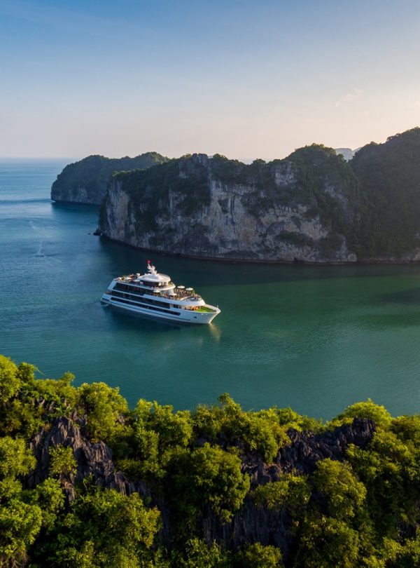 Luxurious yacht sailing between limestone karsts in Halong Bay, Vietnam.