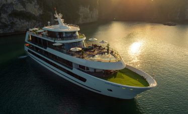 Luxurious cruise boat sailing in stunning Halong Bay at sunset, Vietnam.