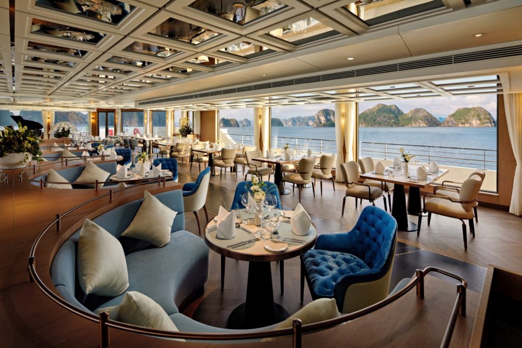 Luxurious cruise ship restaurant with panoramic ocean views and elegant decor.