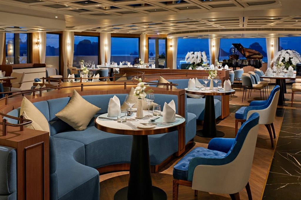 Elegant cruise ship restaurant with ocean views and luxurious interior decor.