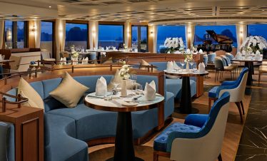 Elegant cruise ship restaurant with ocean views and luxurious interior decor.