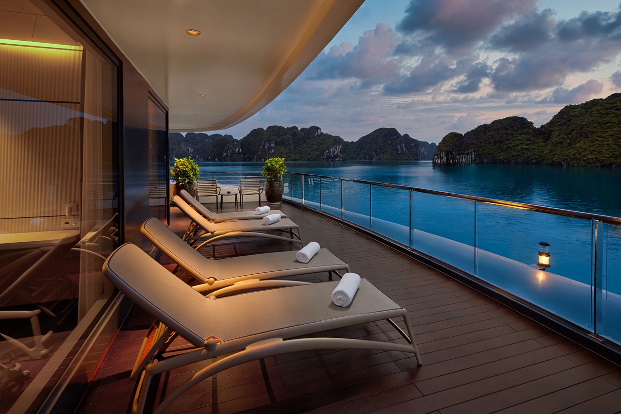 Luxurious yacht balcony with sea view and tropical islands in the background.