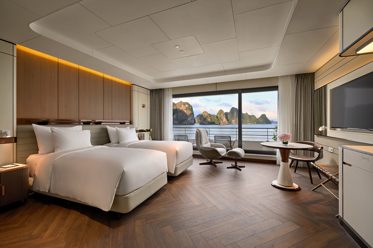 Luxury sea view hotel room with modern decor and balcony overlooking limestone islands, relaxing atmosphere for travelers.