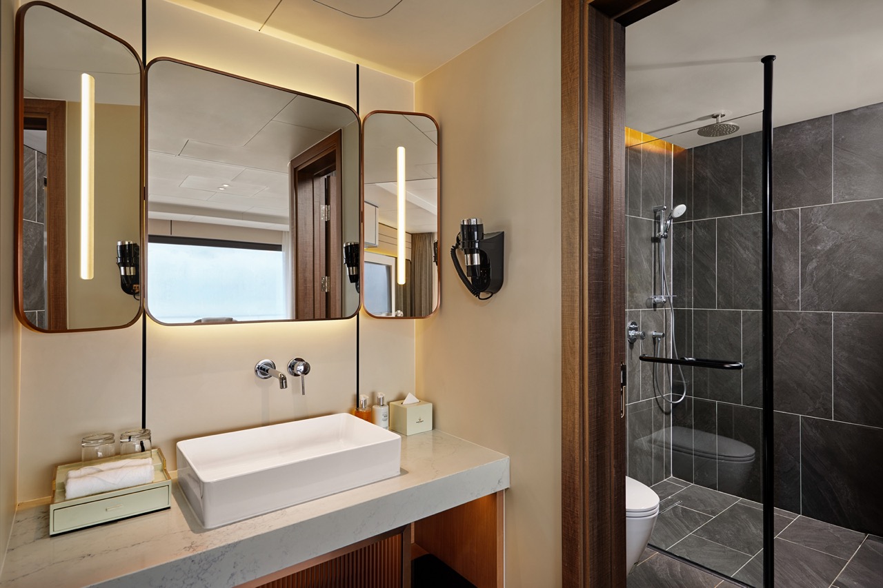Modern luxury bathroom with walk-in shower, stylish mirrors, and sleek design - ideal for Vietnam travel experiences.