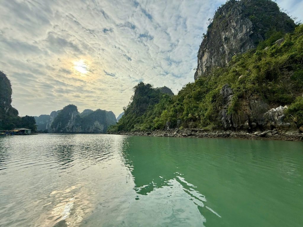 Tranquil river surrounded by lush green limestone mountains in Vietnam.