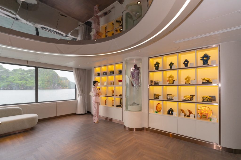 Elegant interior of a tour agency with display shelves showcasing souvenirs and scenic lake view through large windows.