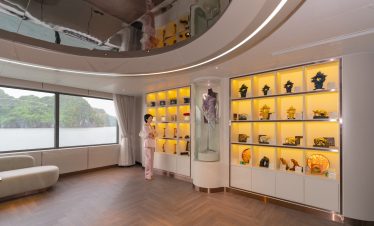Elegant interior of a tour agency with display shelves showcasing souvenirs and scenic lake view through large windows.