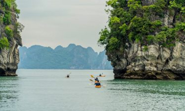 Kayaking among limestone karsts in Ha Long Bay, Vietnam.