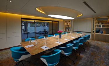Modern corporate meeting room with conference table and stylish chairs, perfect for business events.