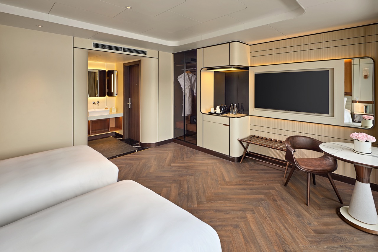 Modern hotel room with stylish decor, flat-screen TV, and comfortable bedding for a luxurious stay.