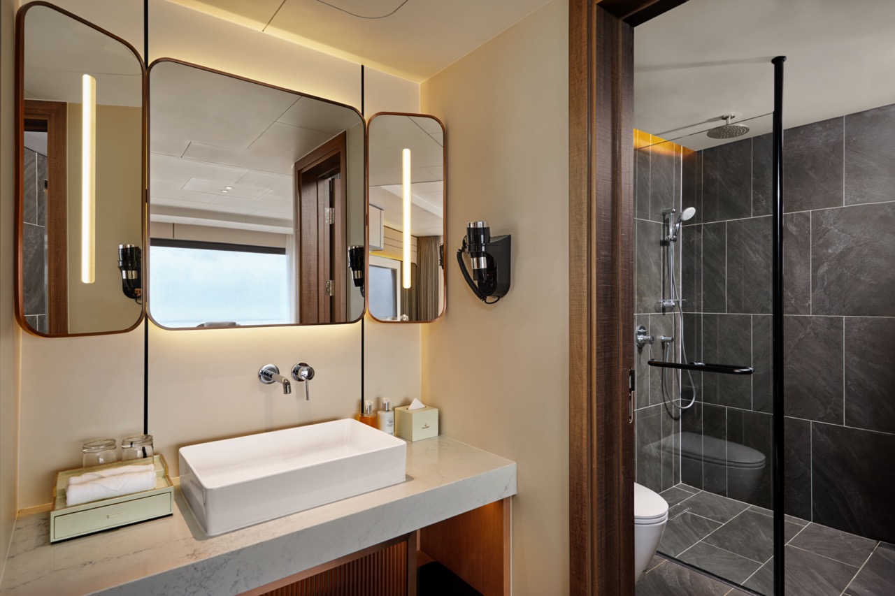 Modern stylish bathroom with vanity sink and walk-in shower, elegant design, high-end amenities, perfect for luxury hotel stays.