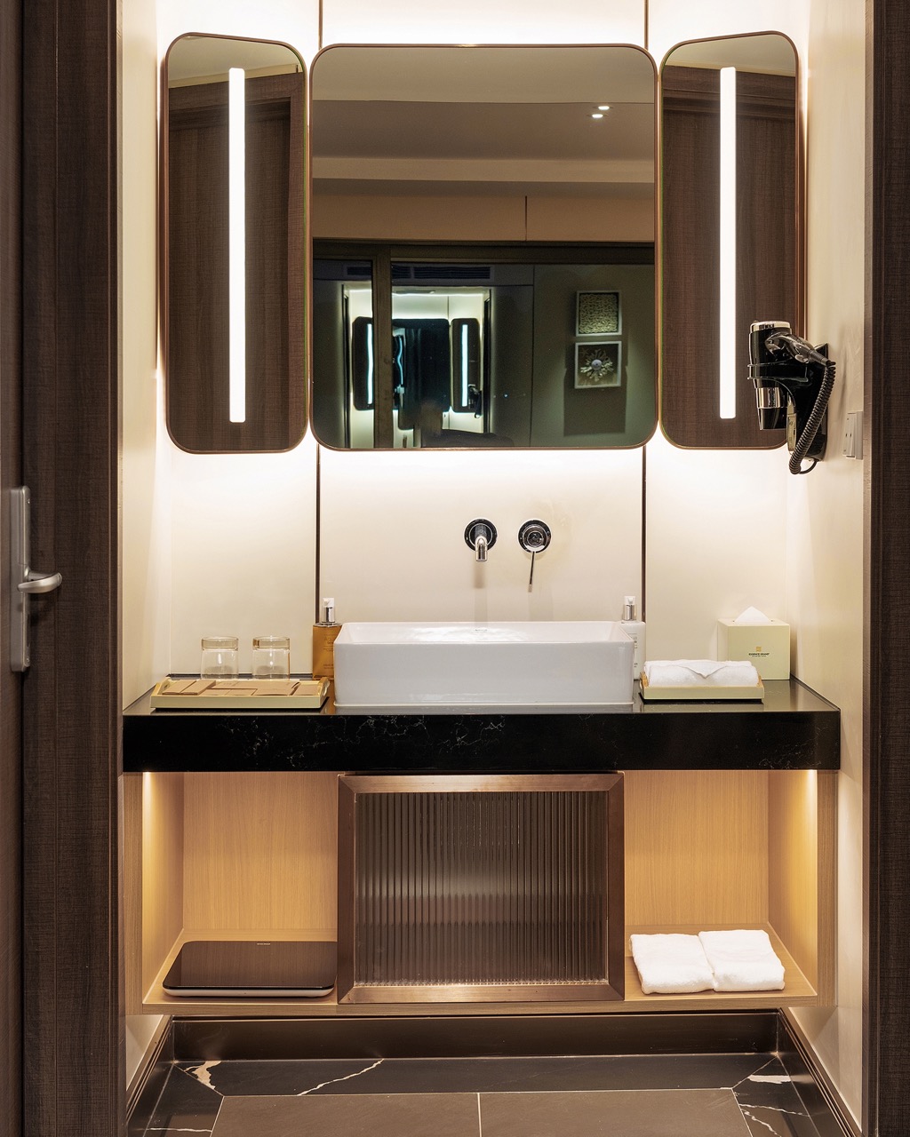 Modern hotel bathroom with stylish mirror, sink, and amenities for a luxurious stay.