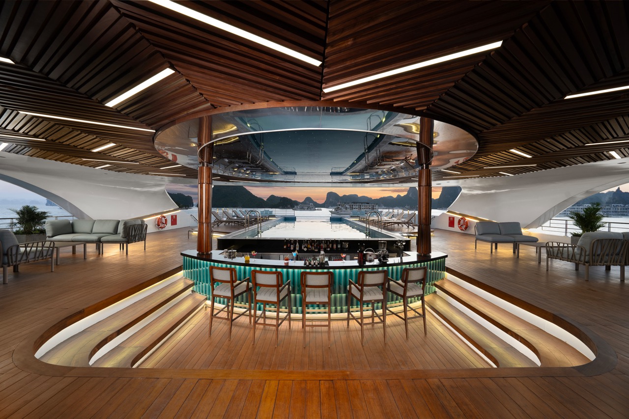 Luxury yacht indoor bar with panoramic ocean views at sunset, modern wooden design.