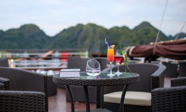 Bright cocktails on a terrace overlooking lush green mountains, perfect for Vietnam travel experiences.