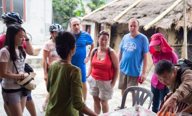 Friendly tour group receiving cultural explanation in rural Vietnam, high-quality travel experience with ViettrendTour.