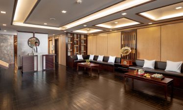 Elegant hotel lobby with modern decor, wooden accents, and comfortable seating area for guests.
