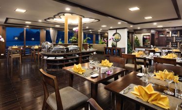 Elegant restaurant interior with festive decor and ocean view, perfect for dining experiences.