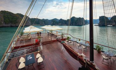 Luxurious cruise ship deck with panoramic views of limestone islands and clear waters in Vietnam.