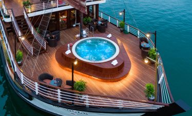 Luxurious yacht deck with private hot tub and outdoor seating, perfect for exclusive cruise experiences.
