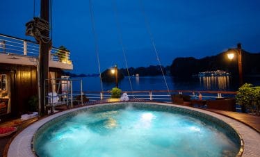 Relaxing night view of a luxury cruise ship hot tub overlooking Halong Bay in Vietnam.