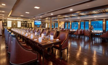 Luxurious cruise restaurant with elegant dining setup and panoramic water views for travelers.