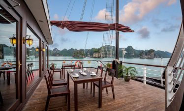 Elegant cruise ship deck overlooking limestone islands in Halong Bay, Vietnam, perfect for luxury travel and sightseeing.