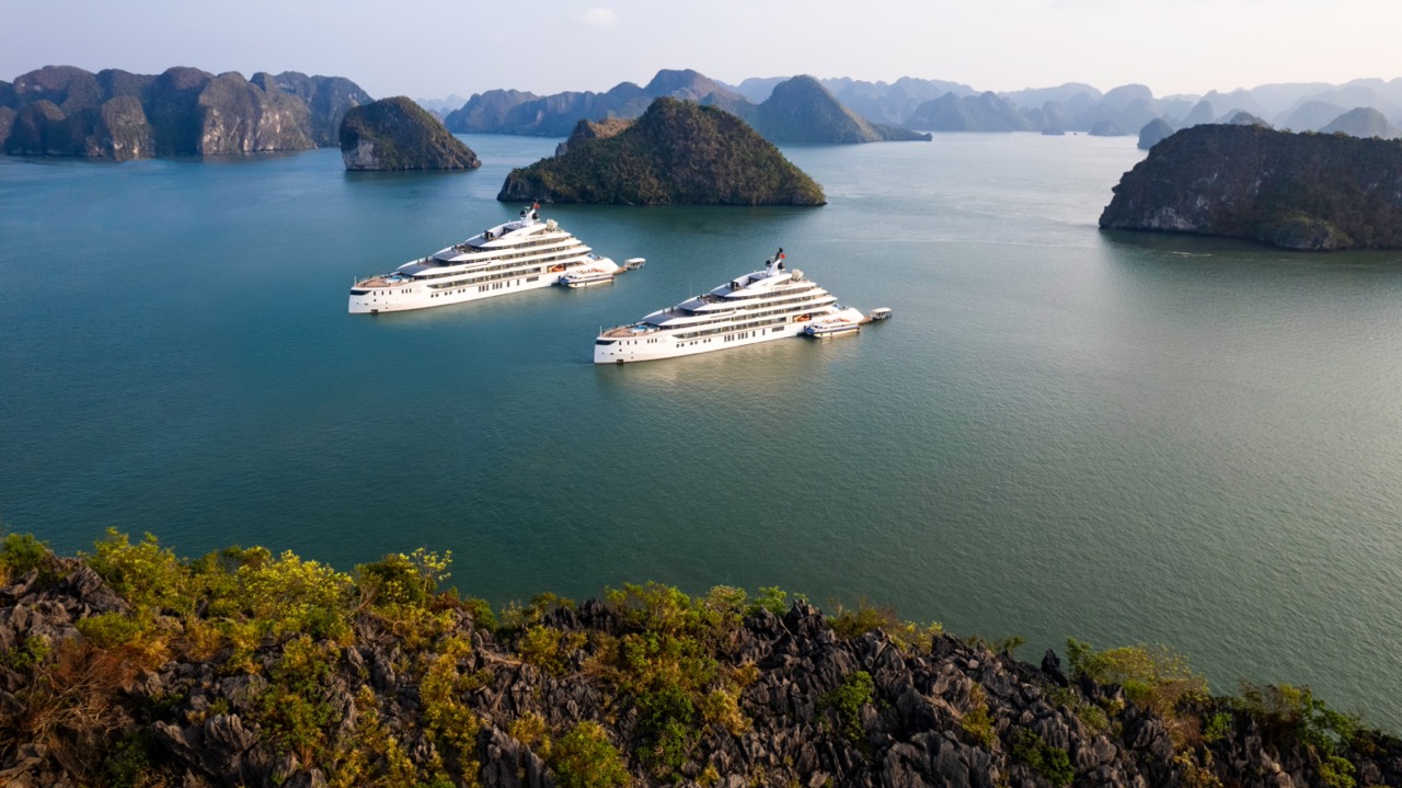 Luxury yachts cruising in Ha Long Bay with limestone karsts and islands, Vietnam.