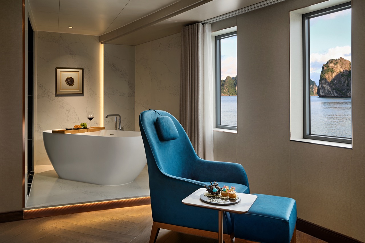 Luxurious hotel room with bathtub overlooking scenic bay view in Vietnam.