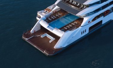 Luxurious yacht with pool and outdoor deck in crystal-clear water.