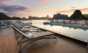 Luxurious rooftop pool with stunning sunset view over limestone islands in Vietnam.