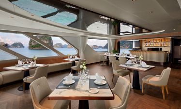 Luxurious onboard restaurant with panoramic sea views and elegant dining setup onboard a cruise ship.