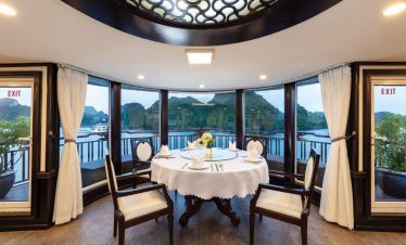 Elegant dining room with panoramic water views and mountain landscape in Vietnam.